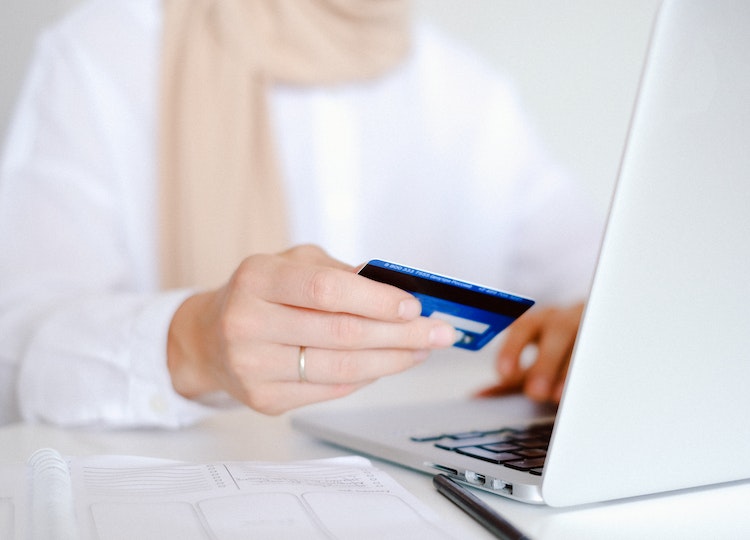 LA guida di Diacomm alla SEO per e-Commerce, rappresentata da una persona con il laptop e carta di credito in mano