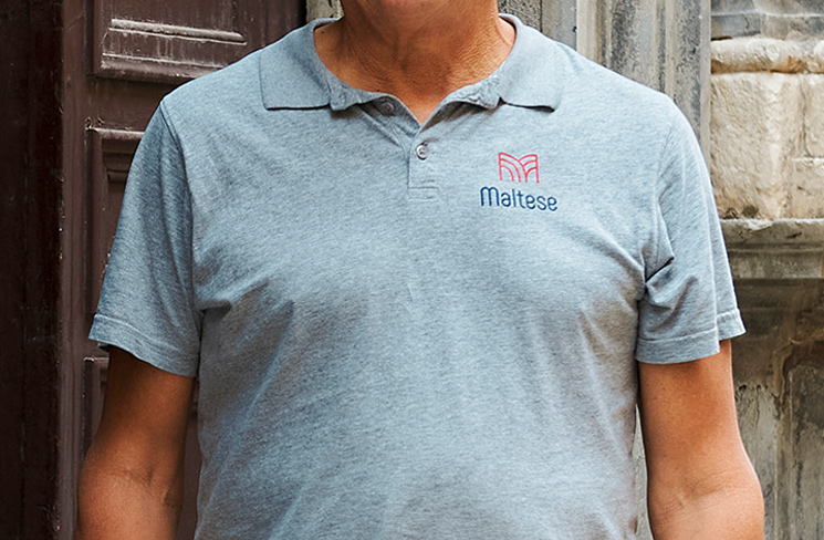 applicazione del logo maltese su polo grigia