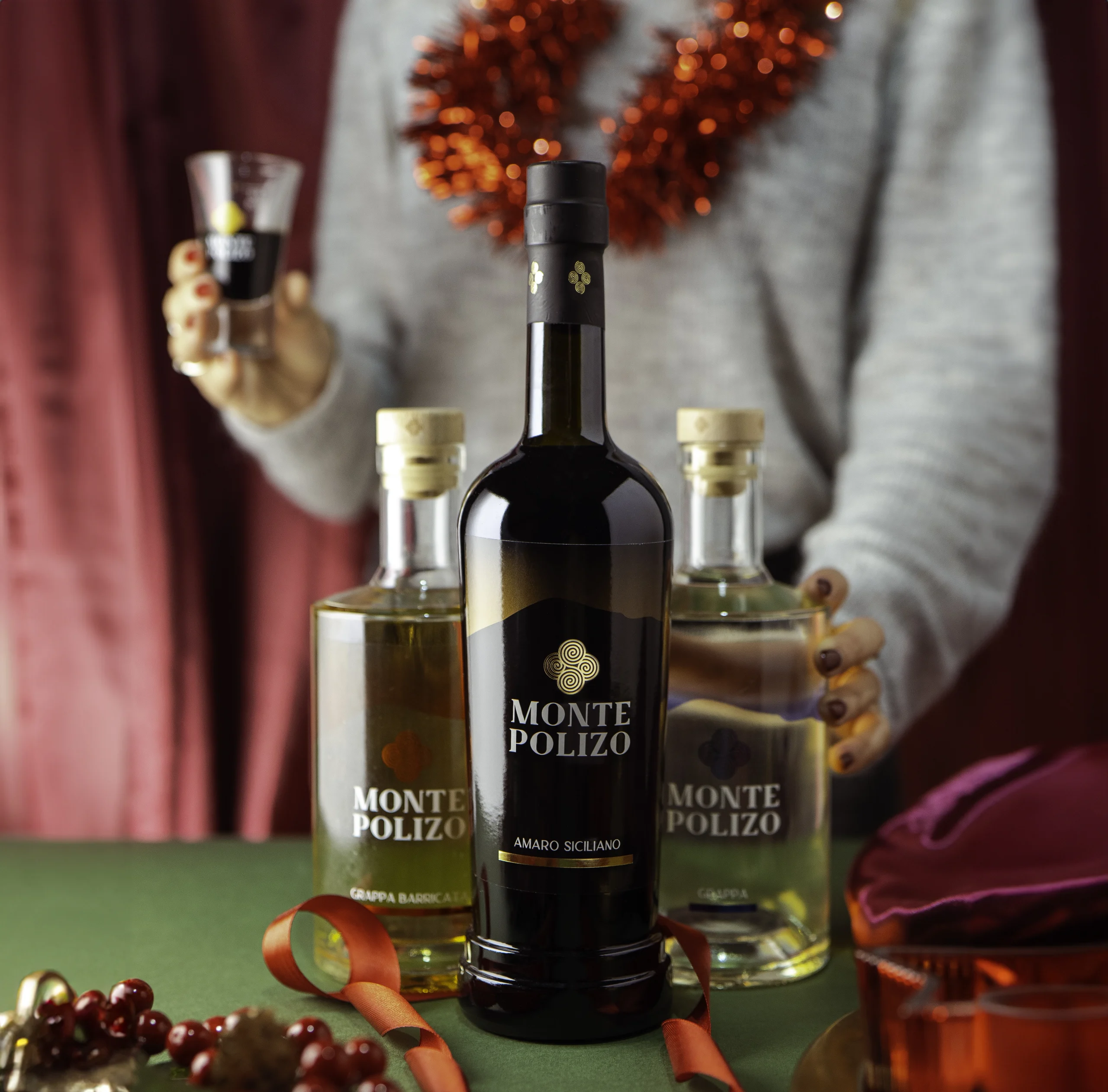 shooting fotografico campagna natalizia Monte Polizo con bottiglia di Amaro, di Grappa Bianca e di Grappa Barricata